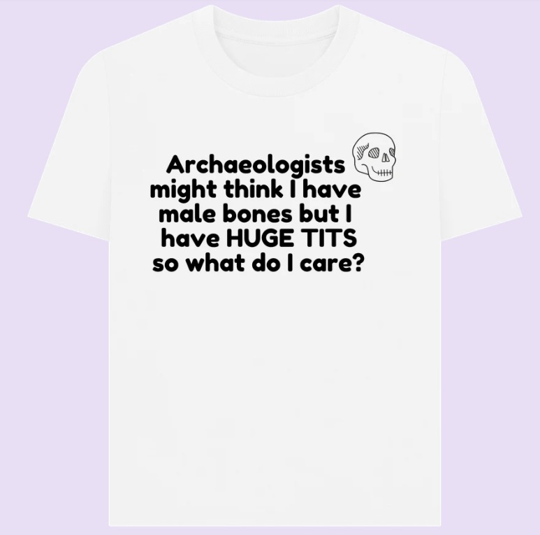 White t-shirt with black skull design and slogan: archaeologists might think I have male bones but I have HUGE TITS so what do I care?